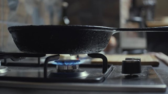 Gas stove ignition and putting pan on it, slow motion, shallow depth of field