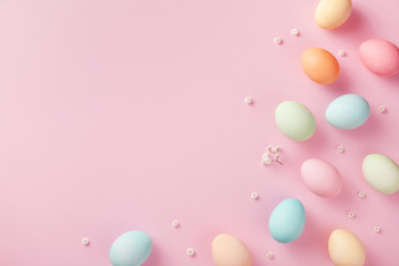 Pastel Easter eggs on pink background top view. Flat lay style.