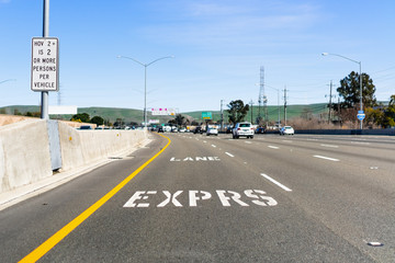 Fototapeta na wymiar Express Lane marking on the freeway; San Francisco Bay Area, California; Express lanes help manage lane capacity by allowing single occupancy vehicles to use them for a fee