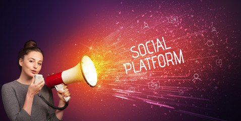 Young woman yelling to loudspeaker with SOCIAL PLATFORM inscription, social networking concept