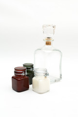 Vintage glass decanter made of transparent glass without a pattern and three colored glass jars on a white background