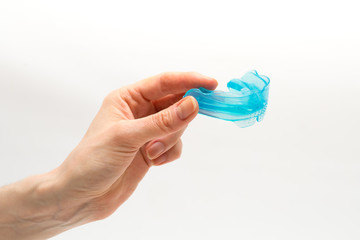 myofunctional trainer for correction of bite and alignment of teeth in the hand of woman on white...