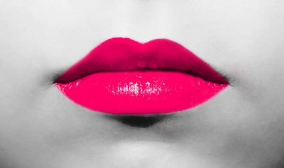 Female lips close-up with burgundy lipstick bright juicy color on a background of black and white face.