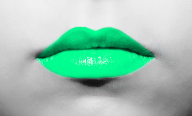 Female lips close-up with light green mint lipstick bright juicy color on a background of black and white face.