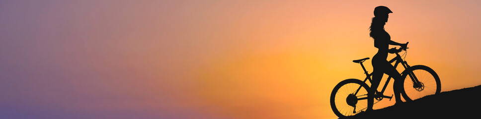 Girl on a mountain bike on offroad, beautiful portrait of a cyclist at sunset, Fitness girl rides a...