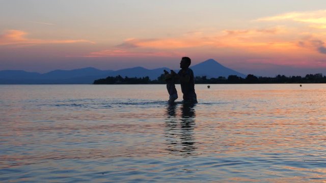 Father with baby girl on seaside. Tourists reflect a healthy lifestyle. CLIMATE-NEUTRAL TRIPS. Family tours, trips. Travel to Europe. Summer vacation background. Travel trend concept