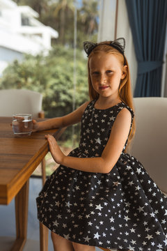 Little girl with red hair shows different emotions. Sadness, joy and happiness. She smiles and cries. In a black dress with skin pigment on her face, freckles
