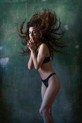 Obraz na płótnie Canvas Curly hair girl fitness body in black bikini