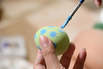 people using paintbrush green and blue watercolor painting on easter egg design custom pattern handicraft for celebration