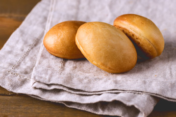 Three Traditional Small Russian Pies on Linen Napkin Wooden Background