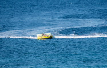 Fototapeta premium speedboat people tubing on the blue sea