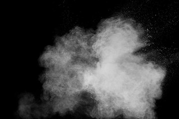 White powder explosion cloud against black background.White dust particles splash.