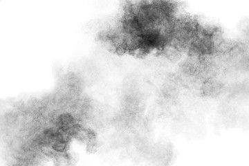 Black powder explosion against white background.Charcoal dust particles cloud.