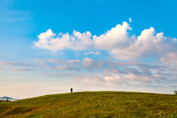 Round hill with beautiful clouds and silhouette