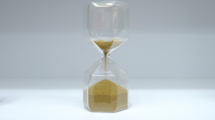 Hourglass close up. Glass hourglass with small balls instead of sand.