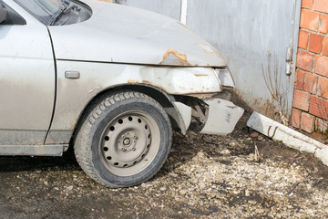 Broken, dirty Russian car on the street. Right wing and wheel.