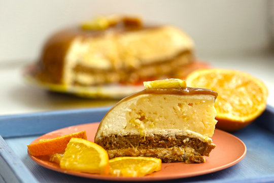 cut orange caramel mousse cake with cream cheese mascapone and chocolate glaze with nuts close up photo