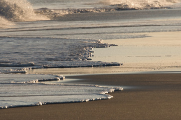 Surf on the beach in the evening sun