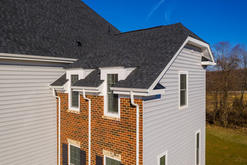 Aerial close up view of triple gutter system e/ eaves on a newly built luxury American estate house...