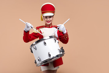 Naklejka premium drummer in a red uniform drums on a drum, show program and celebration.