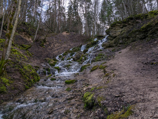 A stream of water flowing over rocks and creating a waterfall effect.