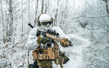 Airsoft man in white camouflage uniform and machinegun with optical sight. Soldier in the winter...
