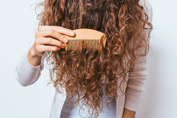 Young woman brushing her curly hair