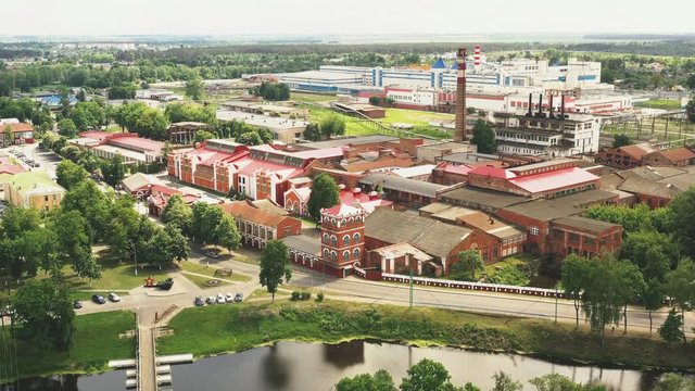 Beautiful old red brick paper mill in the small town of Belarus on the river. Aerial view