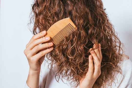 Close-up Young Woman Combing Her Curly Hair