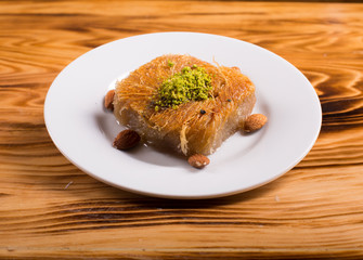 pistachio kadayıf dessert in white plate