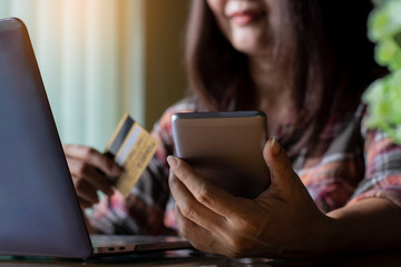 Casual young happy business woman use smart phone and credit card for online shopping and payment .
