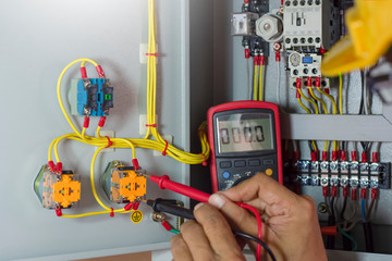 Electrician or repairman  checking electrical terminal box by digital multimeter.