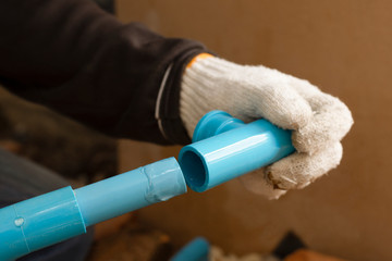 Technician man hand hold pvc water pipe.