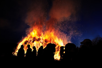 People standing in front of a traditional Easter fire in Germany - 328699694