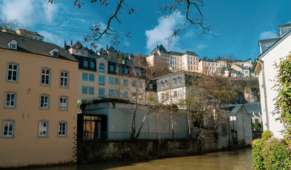Beautiful old European houses on the river in Luxembourg City's Grund (lower city) neighborhood with the old city (upper town) in the background