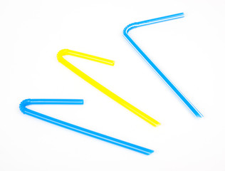 Obraz premium Blue and yellow juice straws on white background
