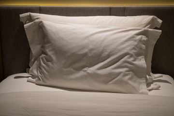 Soft white quilted pillow in bed