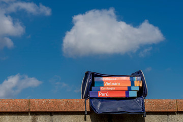 Group of printed tourist guides in a bag against the blue sky with some clouds