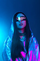 Neon portrait of a girl of Asian appearance, dressed in futuristic clothes and glasses. Neon blue...