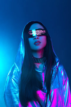 Neon portrait of a girl of Asian appearance, dressed in futuristic clothes and glasses. Neon blue and pink light. Virtual reality glasses and binary code in them.