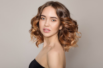 Fototapeta premium Portrait of a young smiling woman. Voluminous wavy hair. on white background