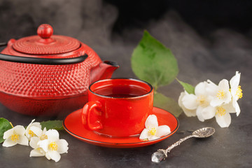 Obraz na płótnie Canvas Glass cup of tea with jasmine flowers