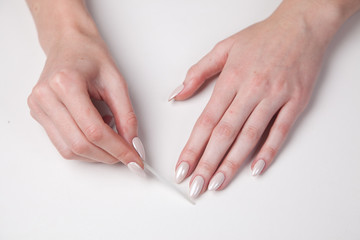 Obraz na płótnie Canvas Girl makes manicure a nail saw