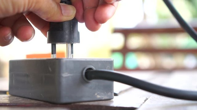 Hands putting socket electricity plug to connect electric multi-socket strip to computer. Black plugs to plugging electrical outlet, Power cable cord connector and electrocute energy danger concept.4K