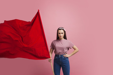 activist and revolutionary, young woman with a red flag on a pink background.