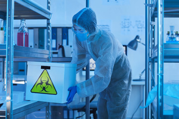 Horizontal shot of unrecognizable female medical scientists putting box with biological hazards on...