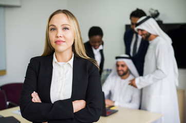 Obraz premium Mixed business team in Dubai. Business meeting with men wearing kandura and western people in the office