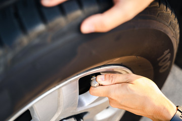 Fototapeta premium Close up of asian man inflating tire in the gas station.