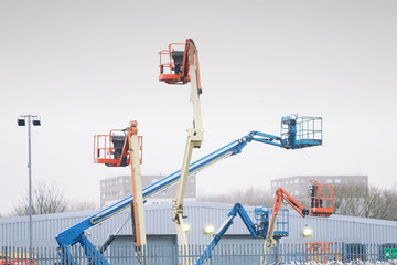 Access platform equipment powered high in sky in blue orange and yellow for high working platform height safety at construction building site