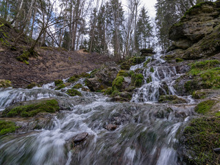 A stream of water flowing over rocks and creating a waterfall effect.
